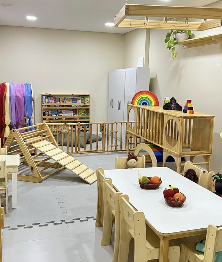 Sala de estimulação da clínica, com estrutura de escalada, tecidos sensoriais e mesa infantil